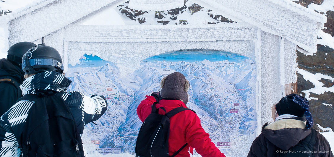 Group of skiers looking at snow-dusted piste map at Valloire ski resort