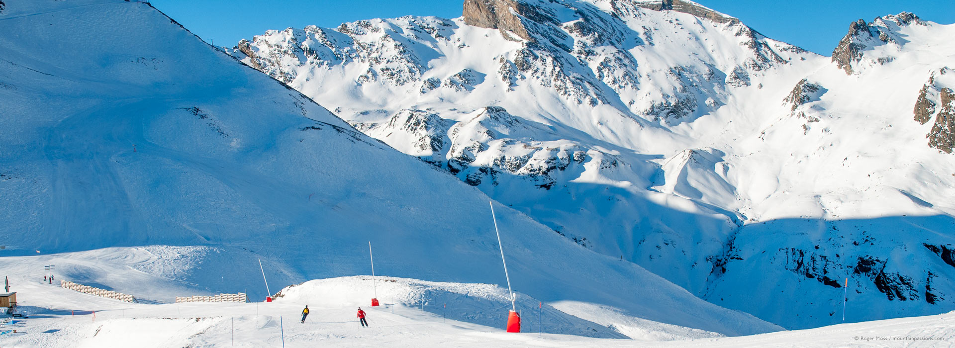 Wide view of mountains with skiers on piste above Piau Engaly.