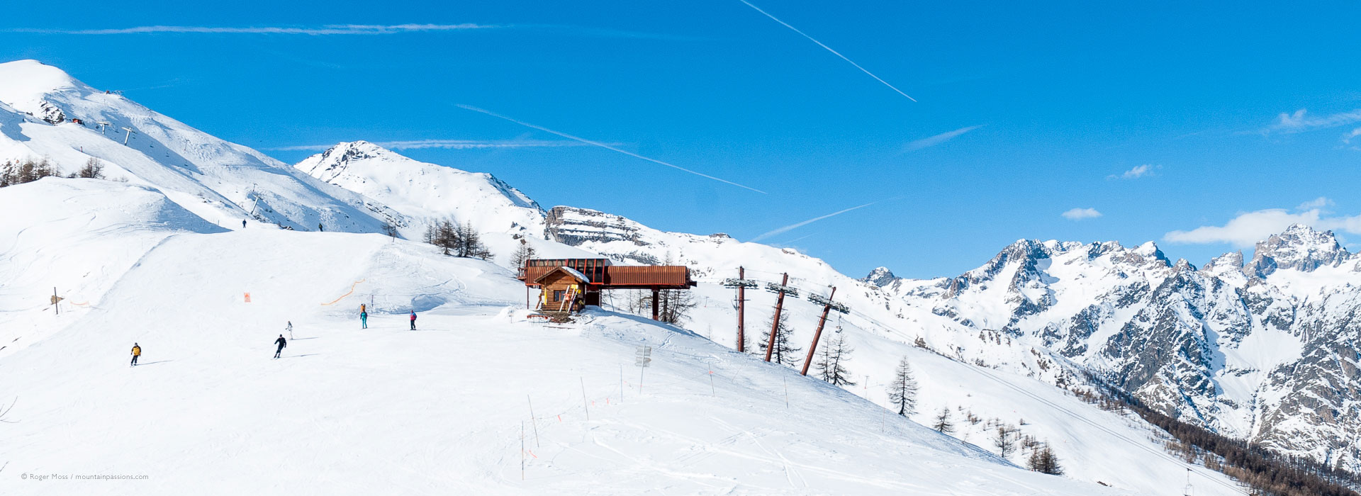 Wide view of skiers leaving high-speed chairlift above Puy Sat Vincent