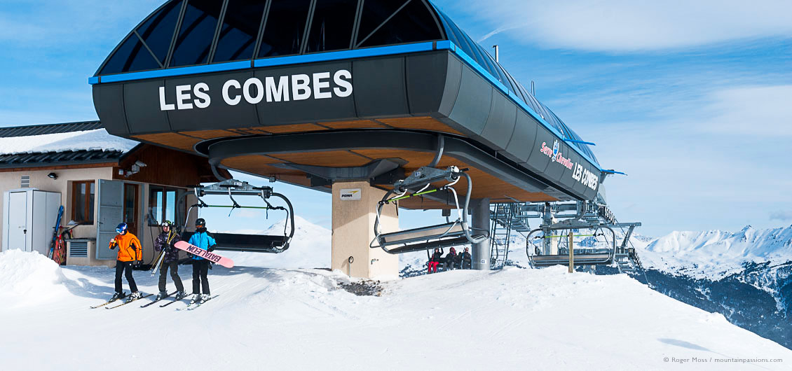 Skiers and snowboarder leaving high-speed chairlift