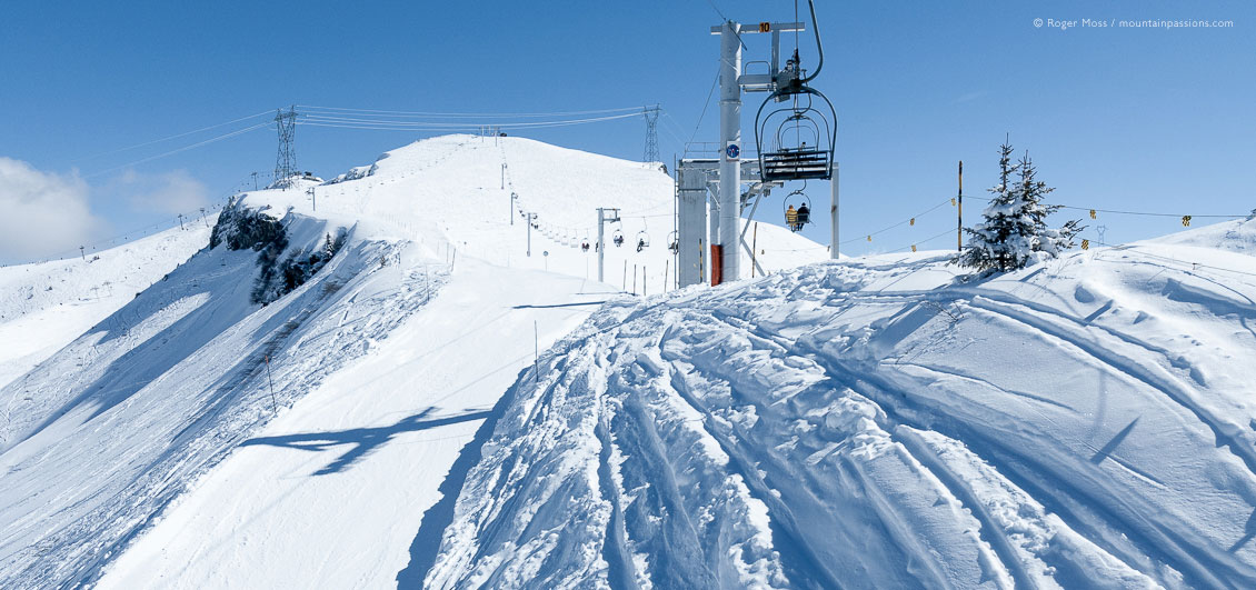 Wide view from chairlift of fresh snow and ski area above Les Carroz