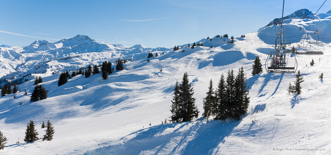 Wide view of ski area in sunshine from chairlift at Areches Beaufort