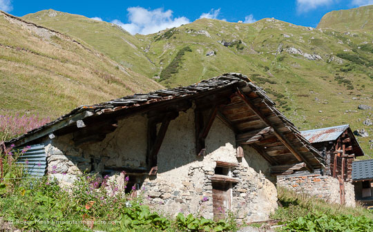 Abandoned stone-built mountain chalets with mountains