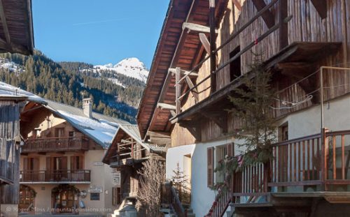 View through heart of village with renovated stone and timber chalets