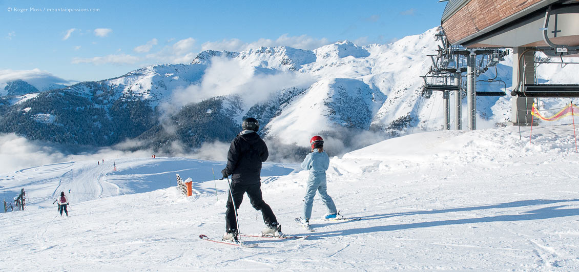 Family skiers beside high-speed chairlift at Saint Francois Longchamp