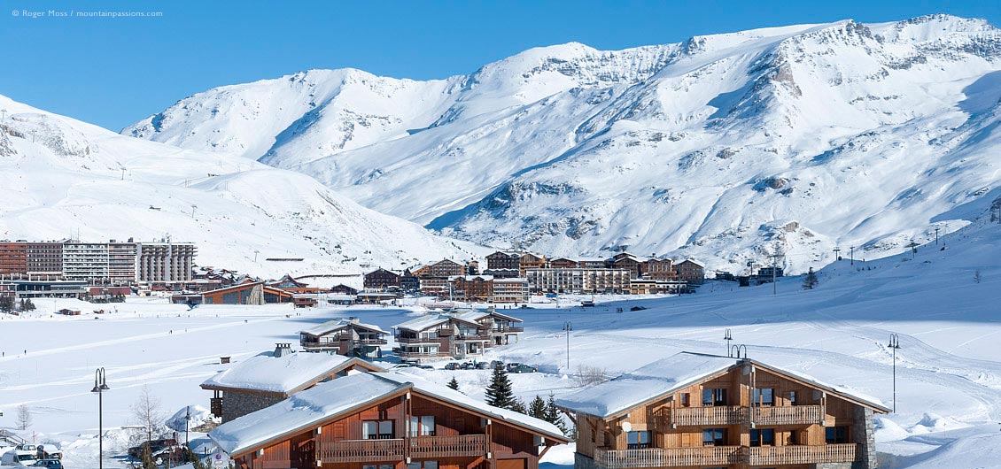 Wide view across frozen, snow-covered lake to ski village