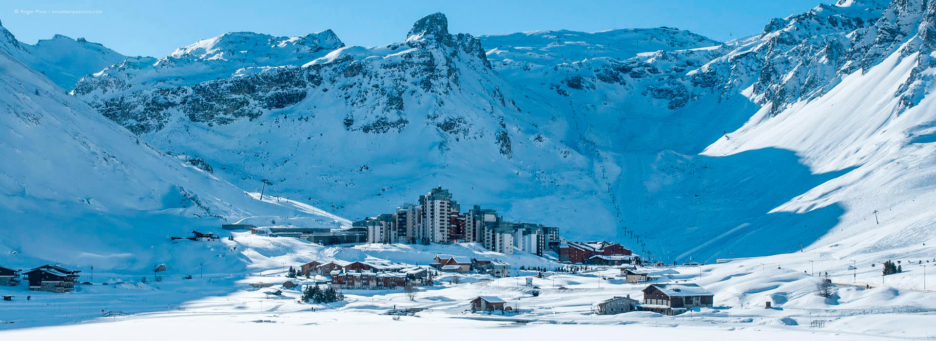 View across snow-covered frozen lake to Tignes Val Claret ski village.