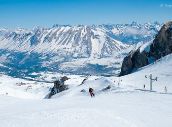 Skiers on piste with mountain views, Le Devoluy, southern French Alps