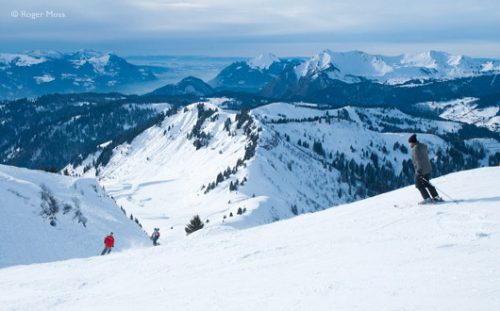 While snow-clouds gather, afternoon skiers head for Les Gets on the Crocus Blue piste, in Morzine's Pleney sector.