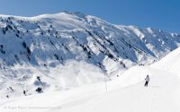 Wide view of skier on piste in valley between La Toussuire and Saint Colomban des Villards, Les Sybelles, French Alps