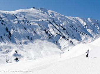 Wide view of skier on piste in valley between La Toussuire and Saint Colomban des Villards, Les Sybelles, French Alps