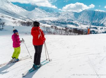 View of two skiers looking at spectacular mountain scenery