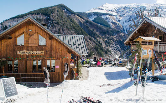 View from piste of skiers on sun terrace of mountain restaurant, St Colomban, Les Sybelles