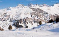 Mountain views, skiers on piste, Areches-Beaufort