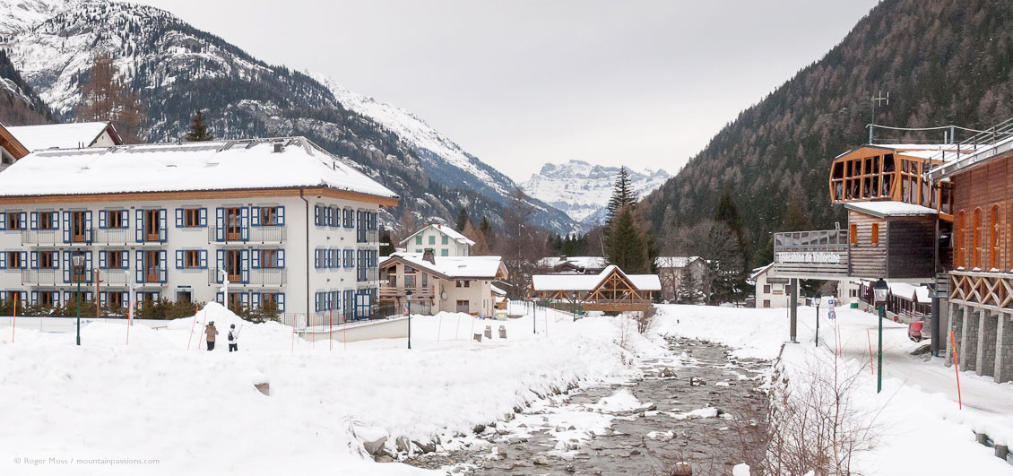 Wide view of village, showing ski apartments, river, gondola lifts and snow-covered valley