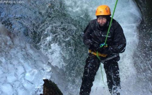 person abseiling down waterfall