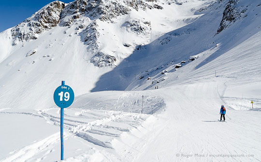 Skier on slow zone piste among wild mountain scenery at Les 2 Alpes