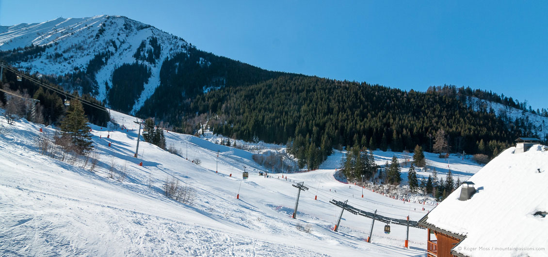 Wide view of ski lifts, pistes and mountains at Oz-en-Oisans