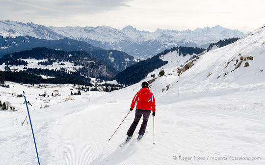 Skier on blue piste above Praz de Lys ski village, French Alps