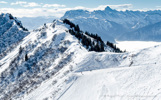 Skiers pausing on scenic piste at Praz de Lys, French Alps.