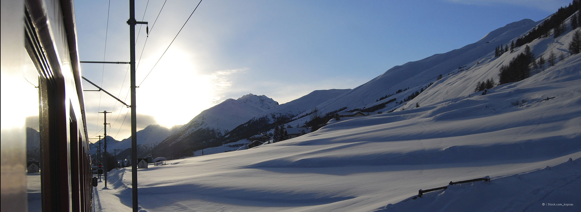 View from train passing through snowy mountains en-route to ski resorts in French Alps