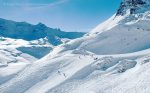 Skiers among big mountain scenery above Tignes