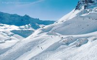 Skiers among big mountain scenery above Tignes
