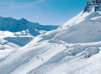 Skiers among big mountain scenery above Tignes