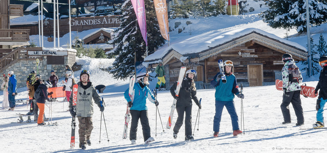 Skiers and snowboarder walking to ski lifts at Courchevel 1850