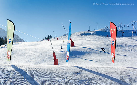 View from foot of pistes of skiers returning to Courchevel Moriond