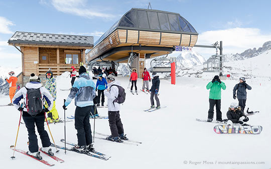 Group of skiers leaving ski-lift above Courchevel 1850, French Alps.