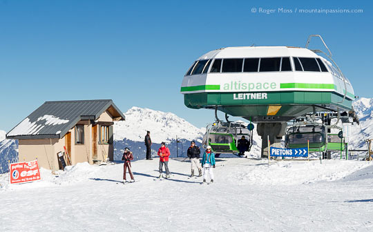 View of skiers leaving Altispace chairlift at Valmorel, French Alps.