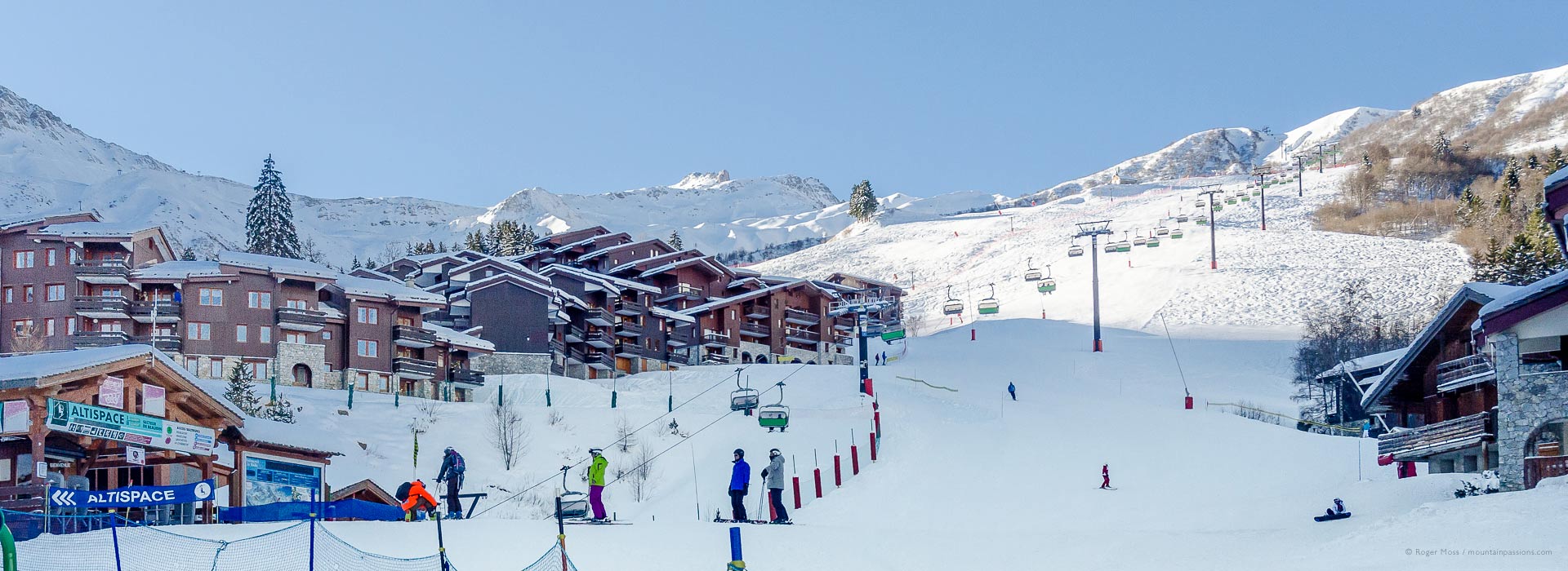 Morning skiers on front-de-neige in Valmorel ski resort, Savoie, French Alps.