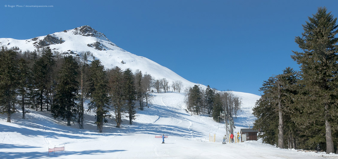 Piste with skiers and drag-lift at Hautacam, French Pyrenees