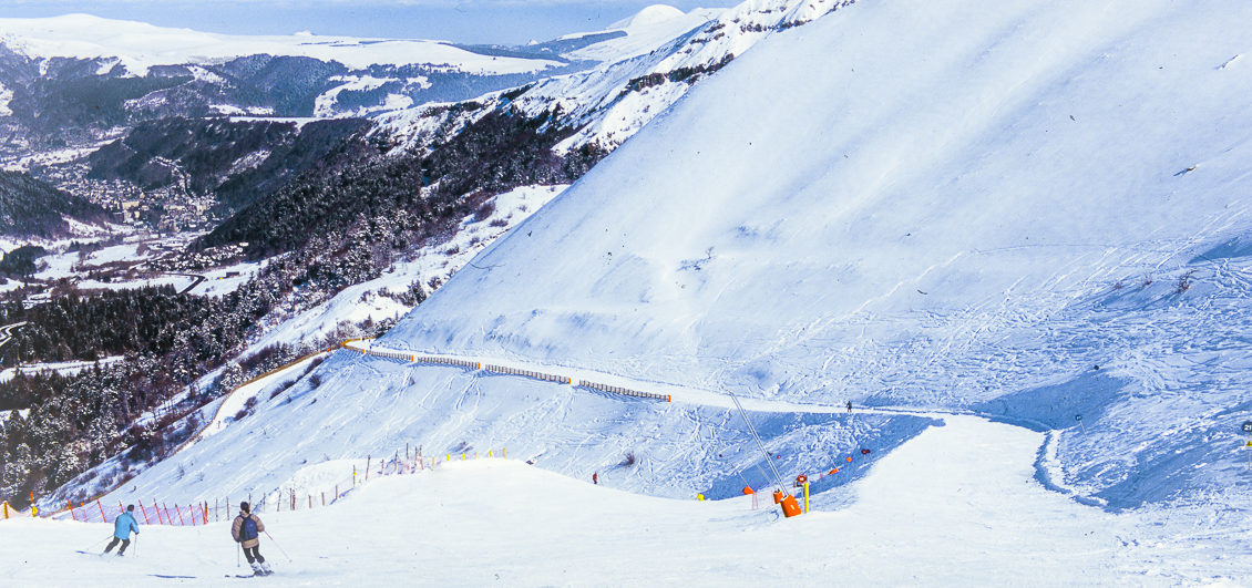 Two skiers on piste at Le Mont Dore, Auvergne, France.