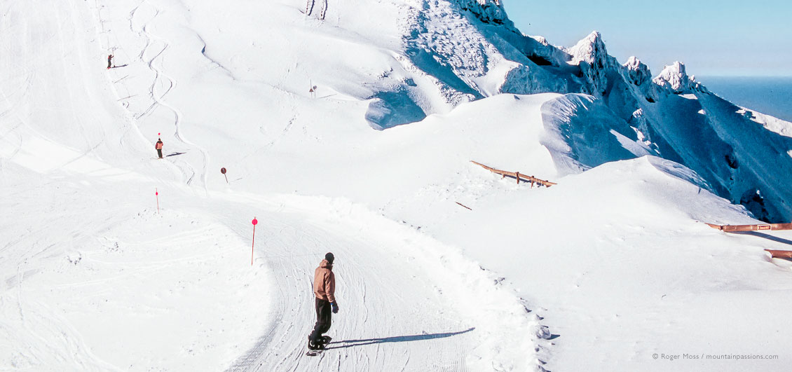 Wide view of snowboarder on upper piste at Le Mont Dore ski area, Auvergne, France