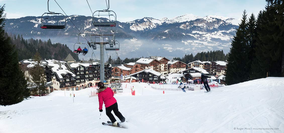 Wide view of skier above Morillon village, Grand Massif, French Alps.