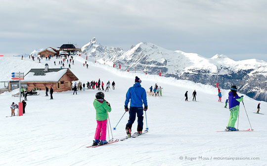 Wide view of skiers with chairlift and mountains, Grand Massif, French Alps