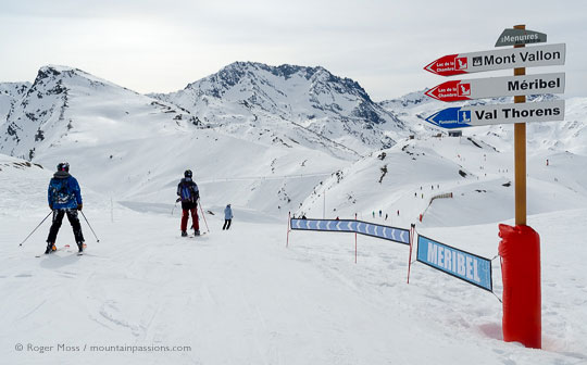 Skiers passing piste sign