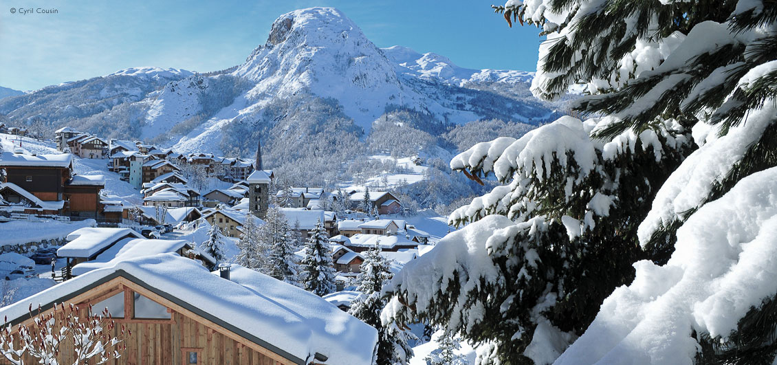 View through snow-covered trees to Saint Martin de Belleville and mountains