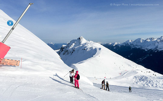 Ski instructor and skiers on mountainside